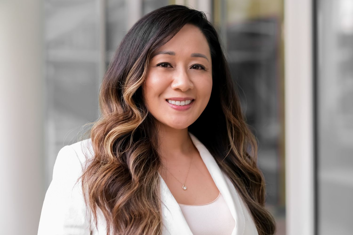 Professional headshot portraits in black and white showing warm smiles and business attire.