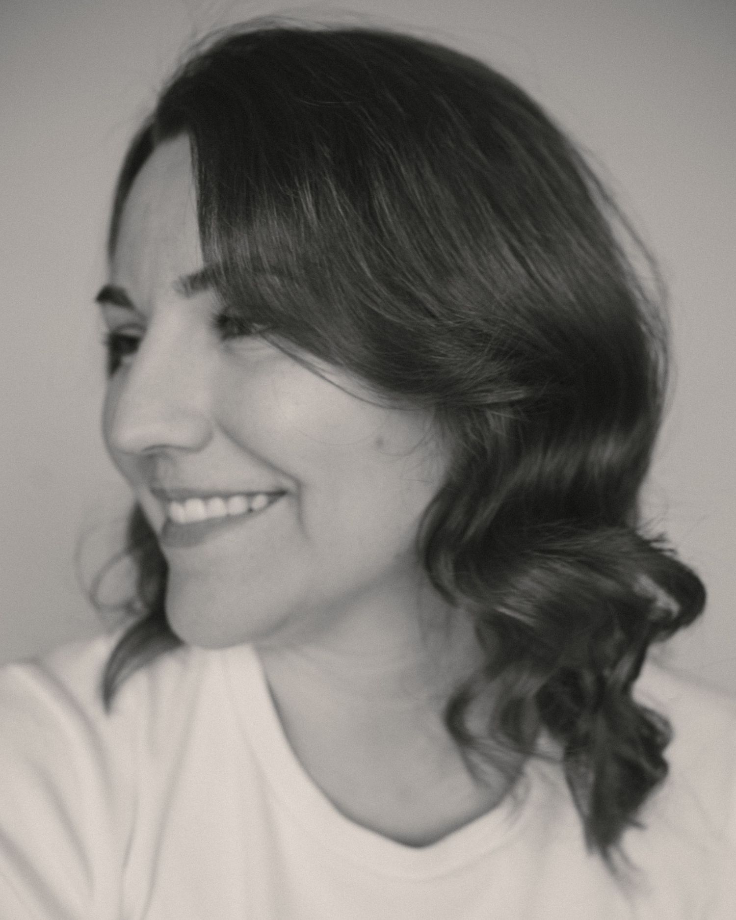 Series of black and white headshots capturing candid smiles and side profiles.