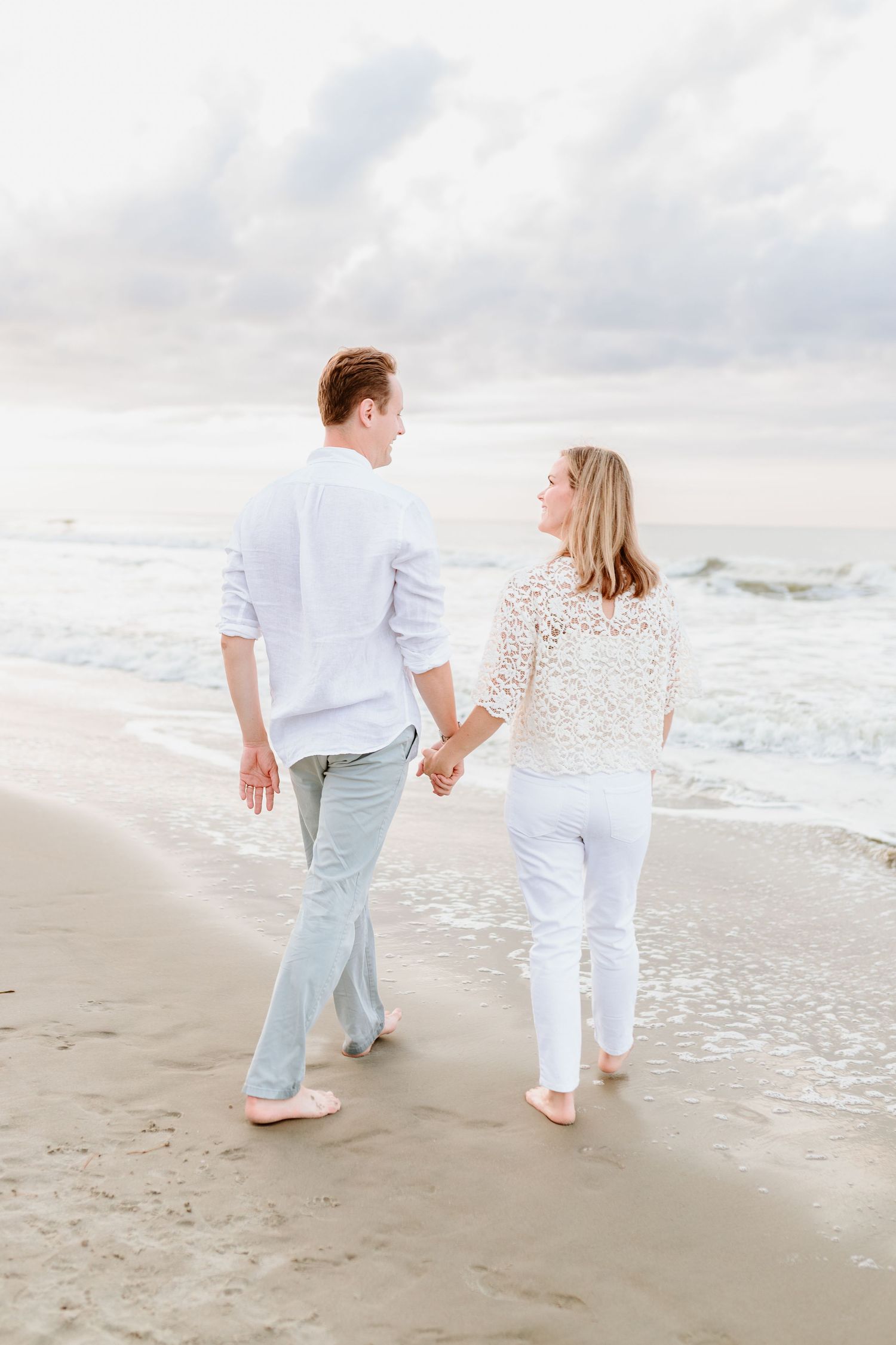 Couple walking hand in hand along peaceful beach at sunset. Isle of Palms, Charleston South Carolina. Salt and Oak Photography.