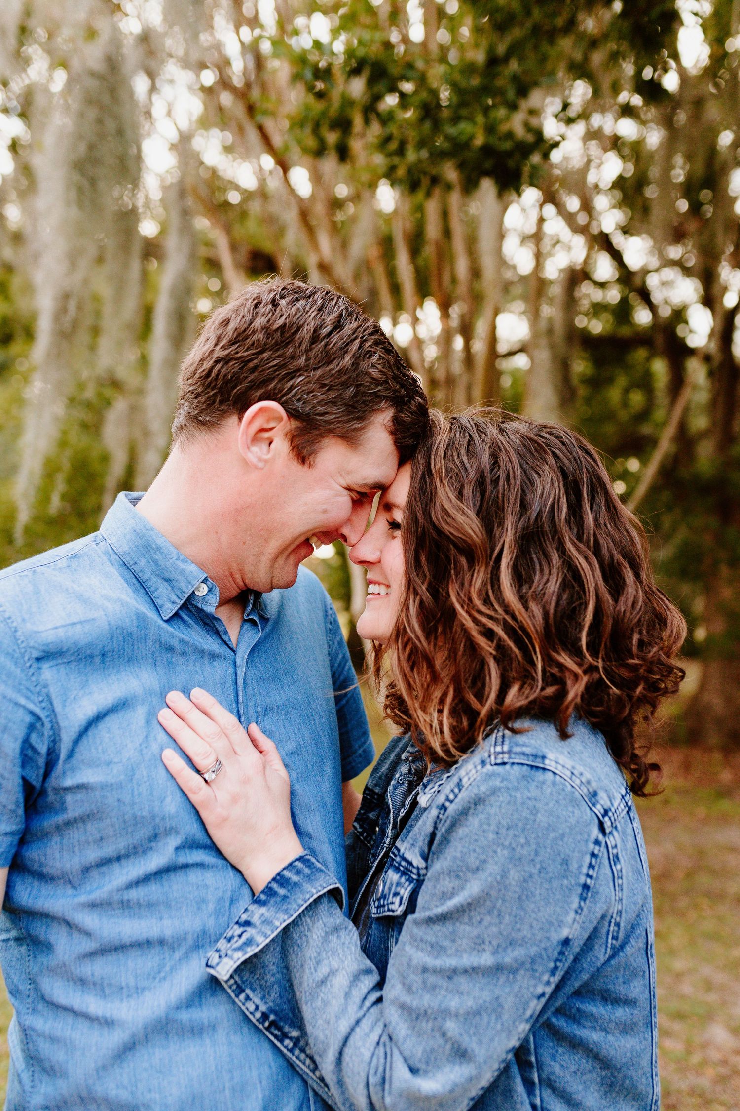 A romantic engagement photo of a couple in denim sharing a tender moment. Charleston, South Carolina. Salt and Oak Photography.
