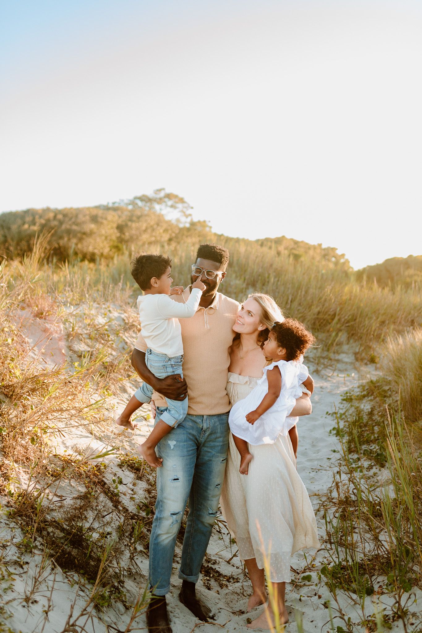 A playful family moment on sandy dunes during golden hour. Charleston, South Carolina. Salt and Oak Photography.