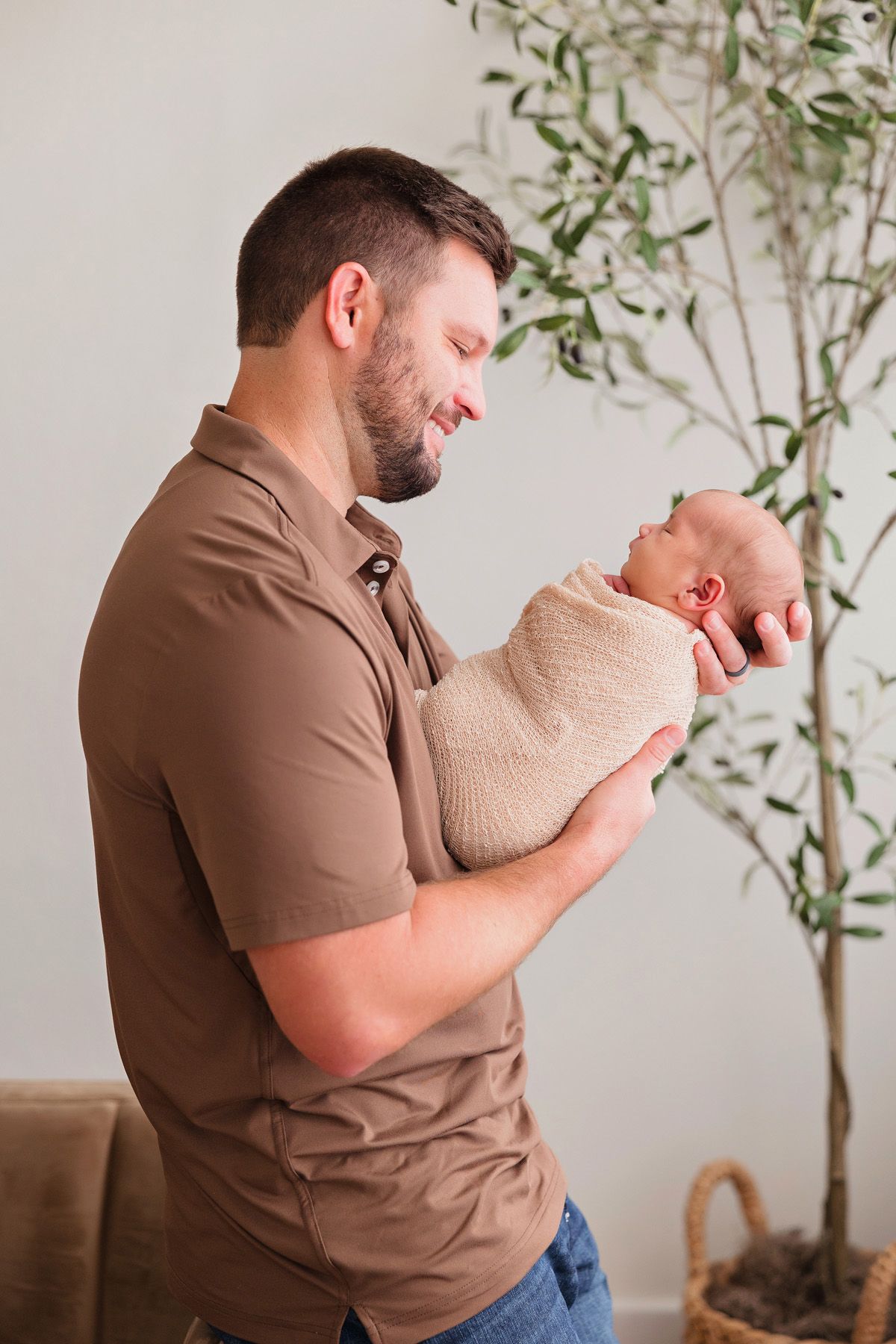 Indoor lifestyle newborn photography session with soft natural lighting and minimalist decor.