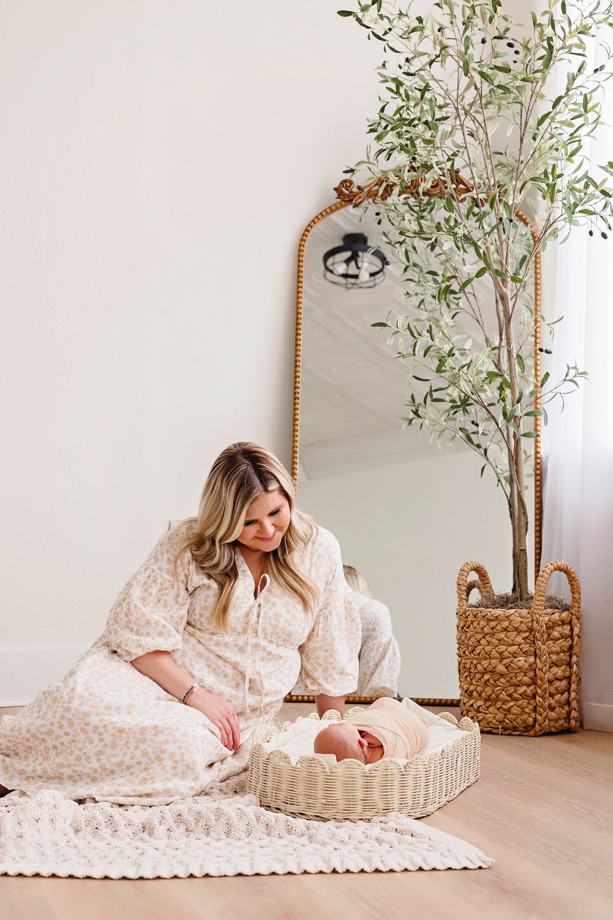 Lifestyle newborn session in bright modern room with woven baskets and greenery.