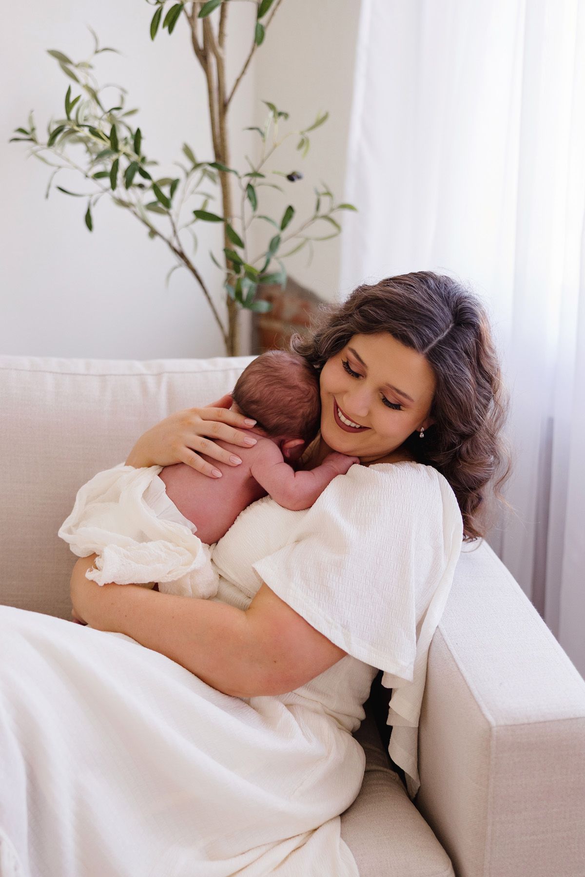 A series of intimate moments showing a baby being held against white clothing in a bright room.