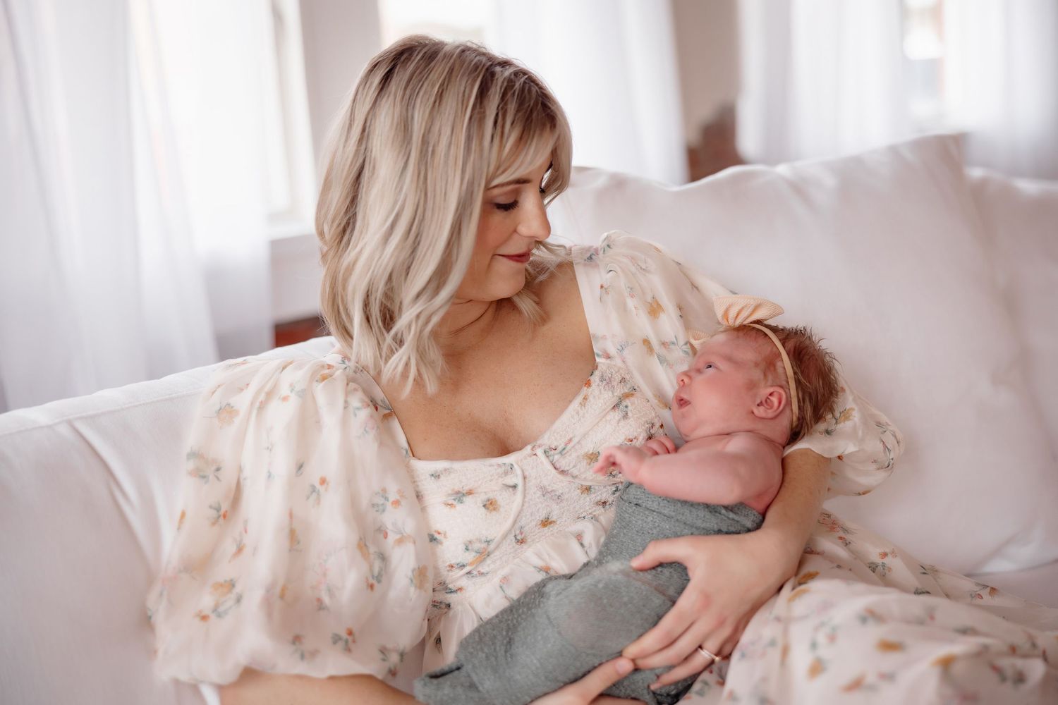 Tender moments with a newborn captured in soft natural window light.