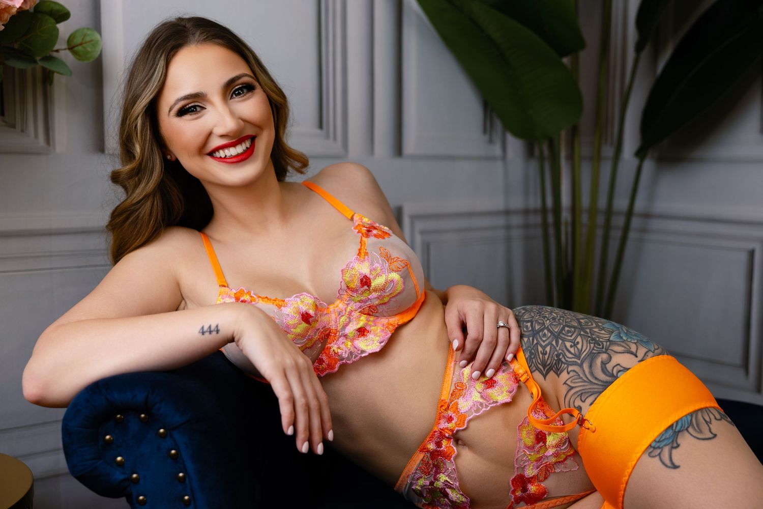 A collection of poses showing someone wearing a floral orange lingerie against a light colored wall with plants.