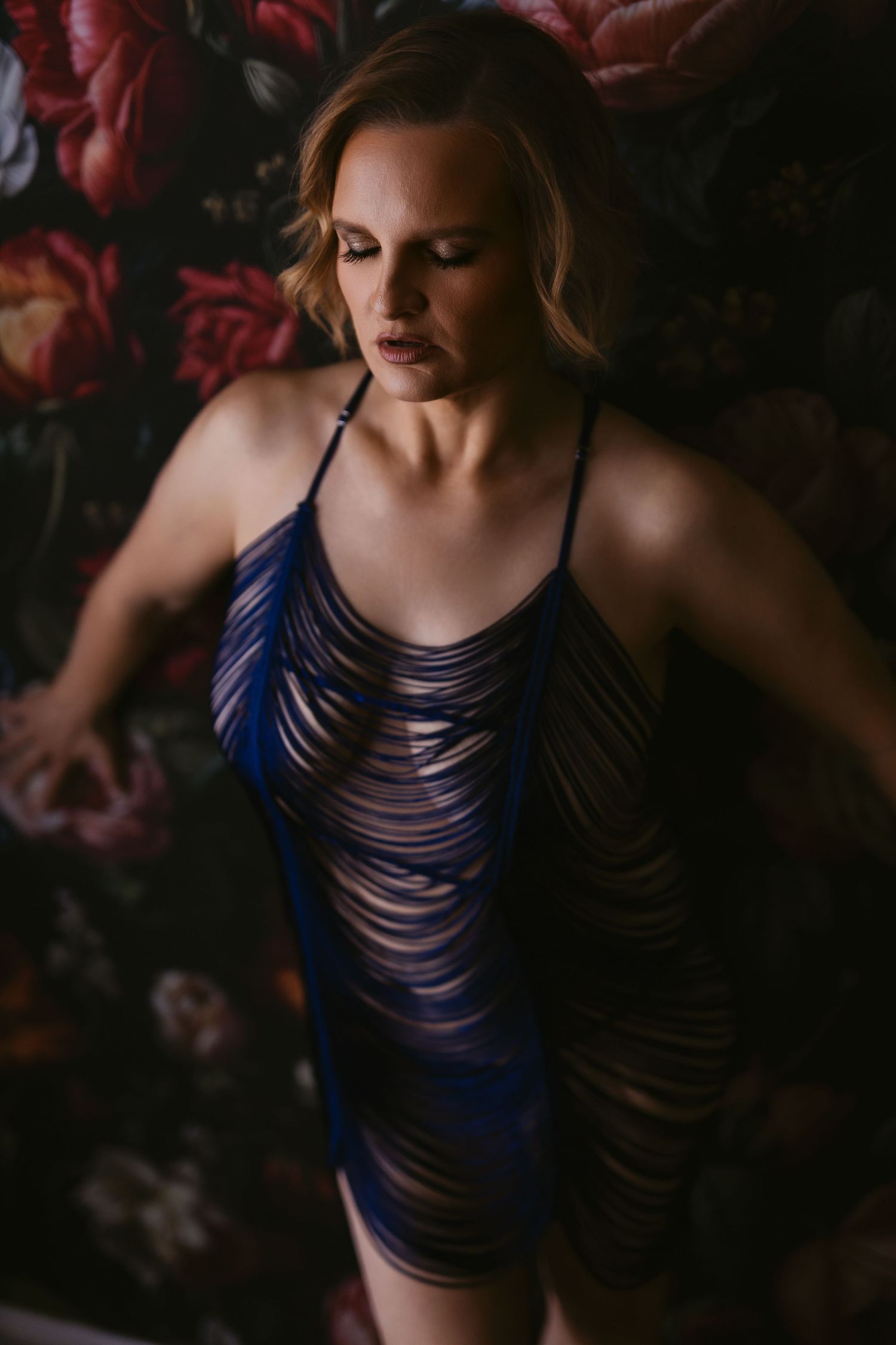A moody artistic photo sequence showing a figure in a navy blue strappy dress against a dark background in LD photography studio.