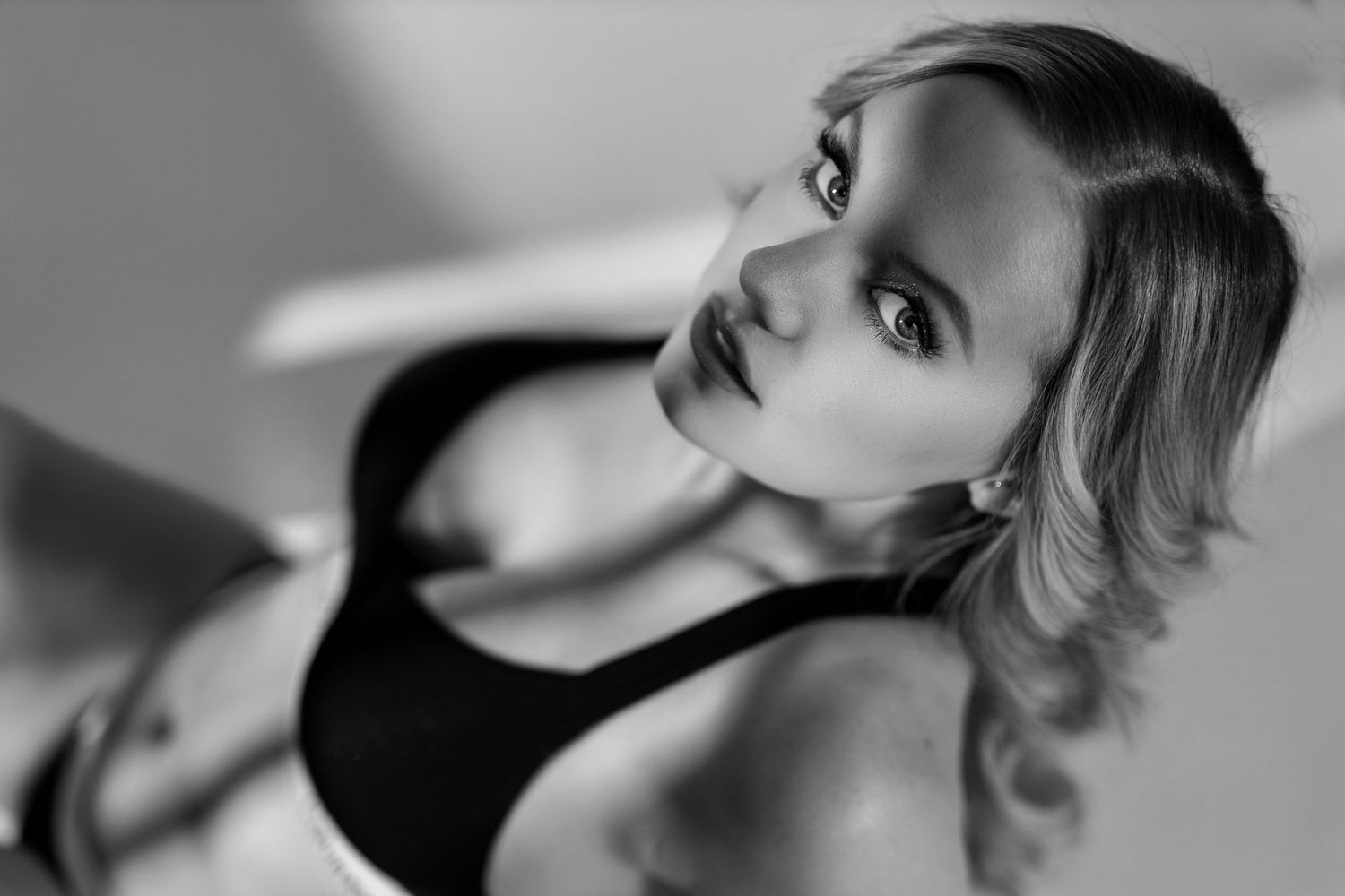Black and white artistic boudoir portrait series showing dramatic close-up facial expressions and poses in monochromatic lighting.