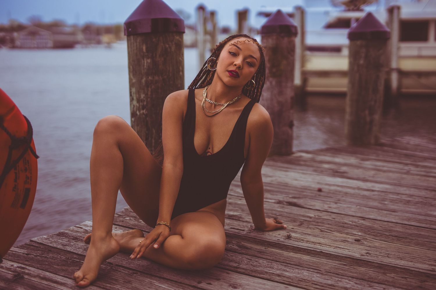 An outdoor boudoir session of a woman relaxing on a wooden dock on downtown Annapolis Maryland.