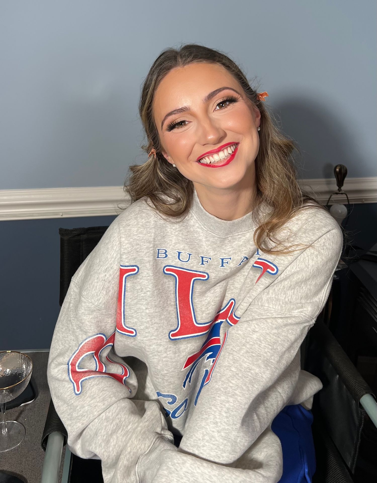 A series of photos showing someone wearing a white Buffalo Bills branded sweatshirt making playful poses.