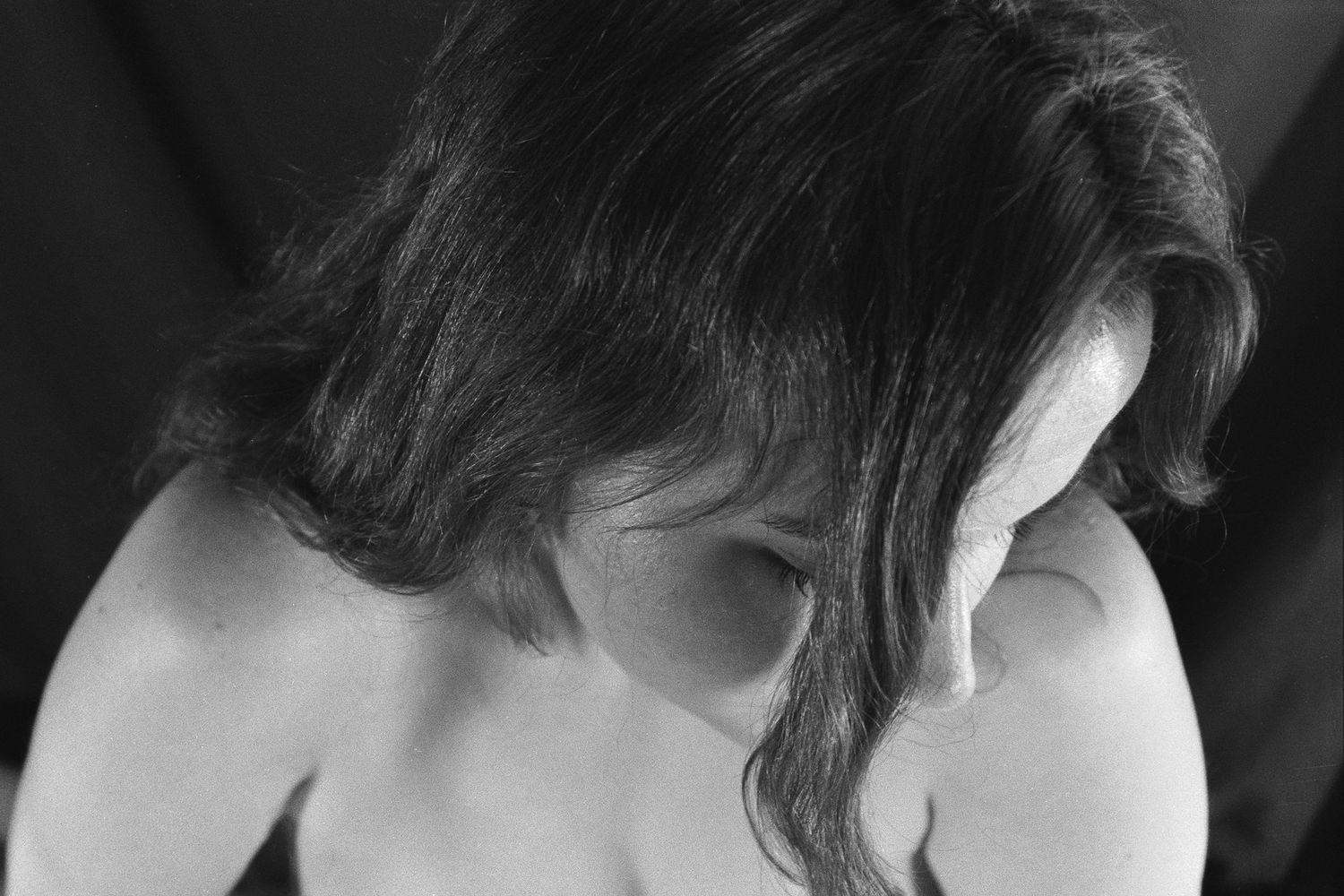 A black & white image on 35mm film of the hottest babe in the universe. Close shot with a high angle, looking down at her dark hair.