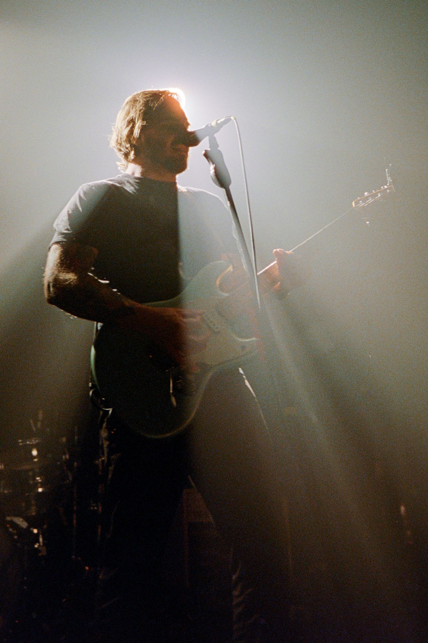 Dustin Kensrue of Thrice bathed in stage lights.