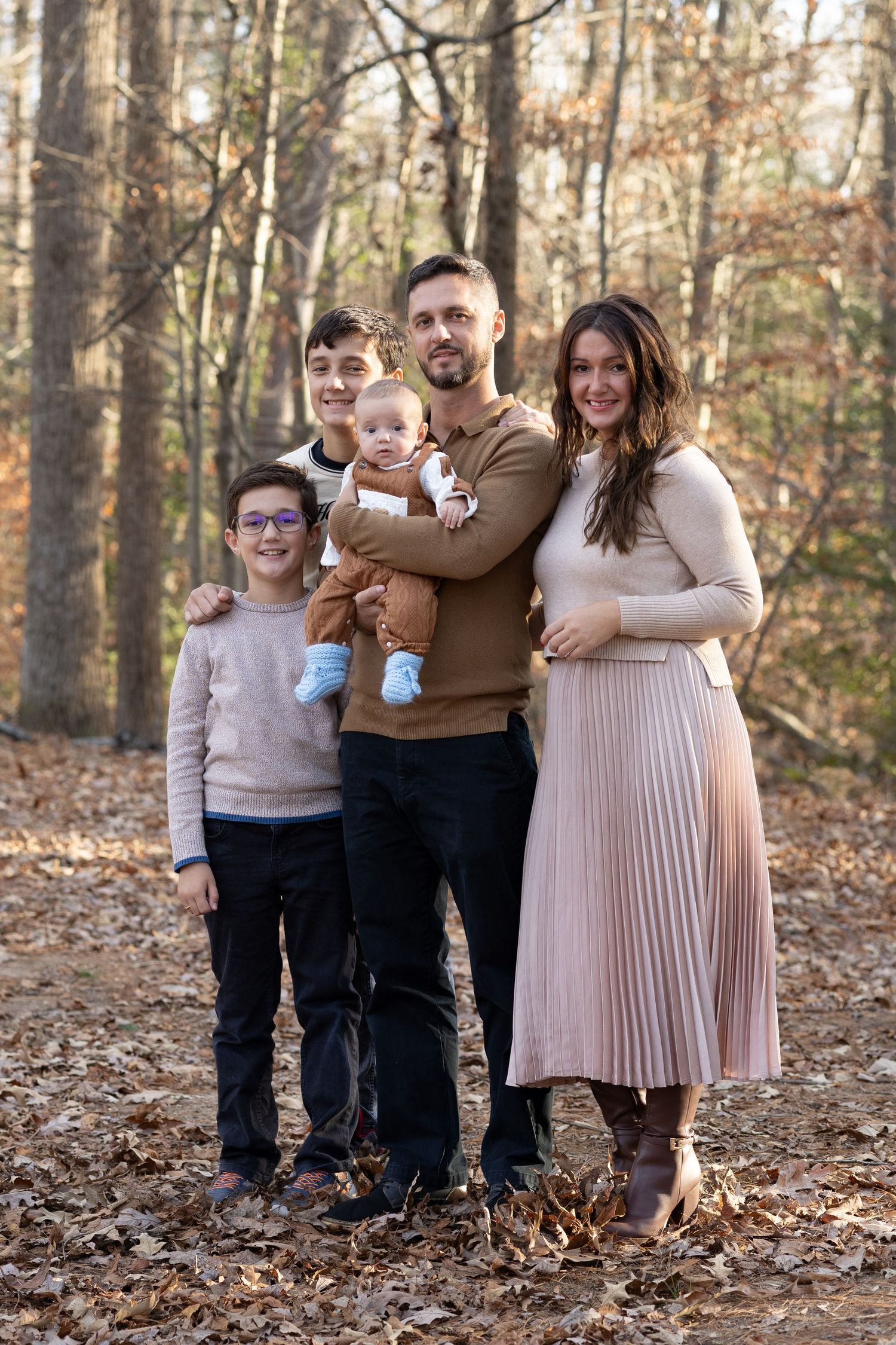 Portrait of a family of five posing in the forest