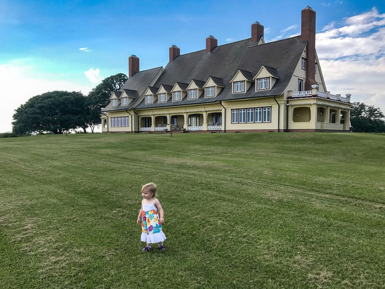 Portrait of a small child in front on the Whalehead Club in the Outer Banks.