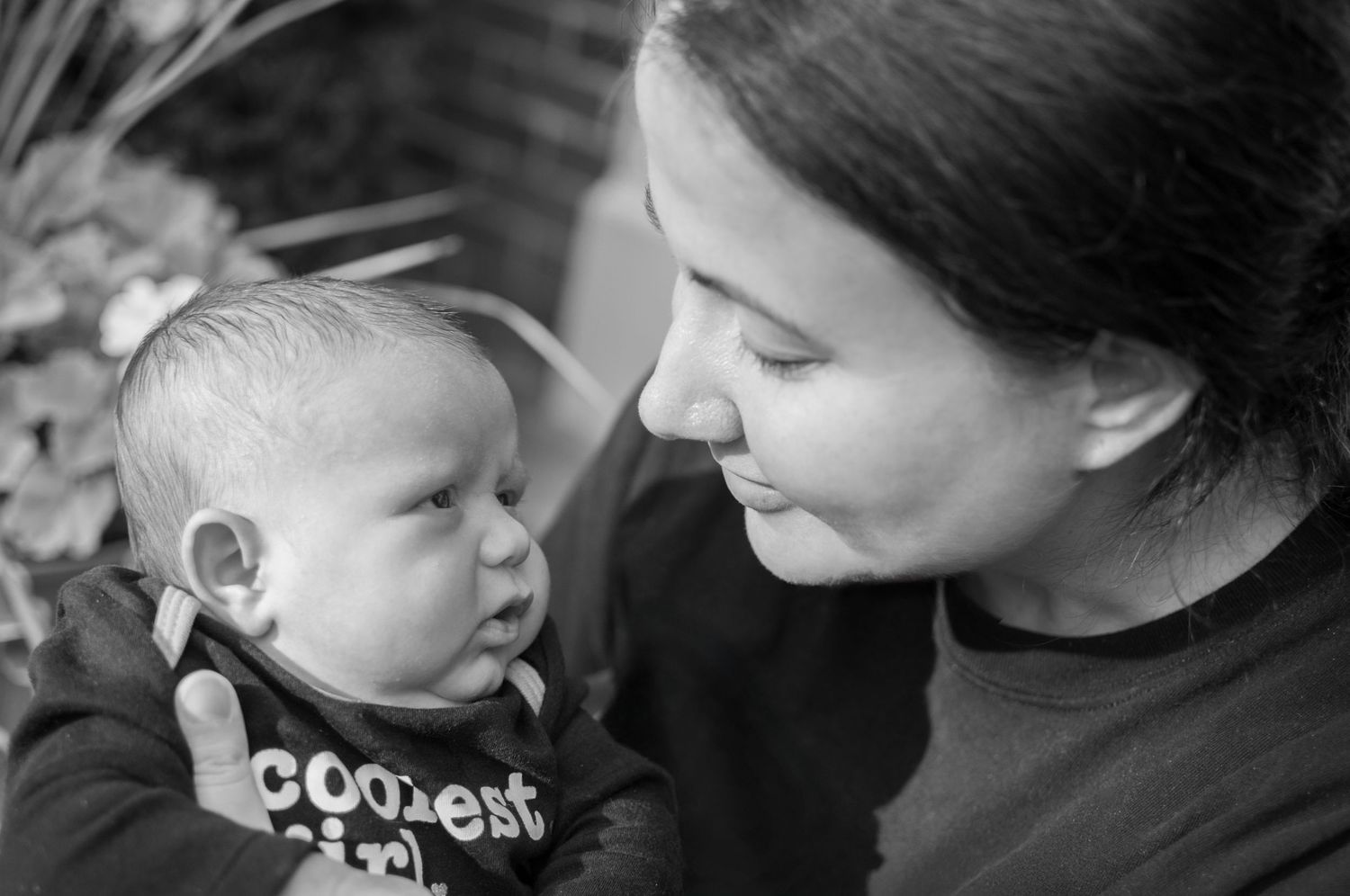 Black and white portrait of a mother holding her baby close to her face