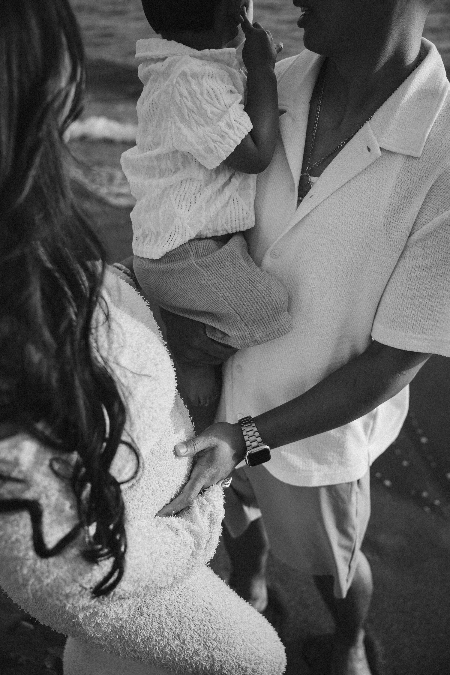 Black and white close-up shot showing hands adjusting a formal white dress.