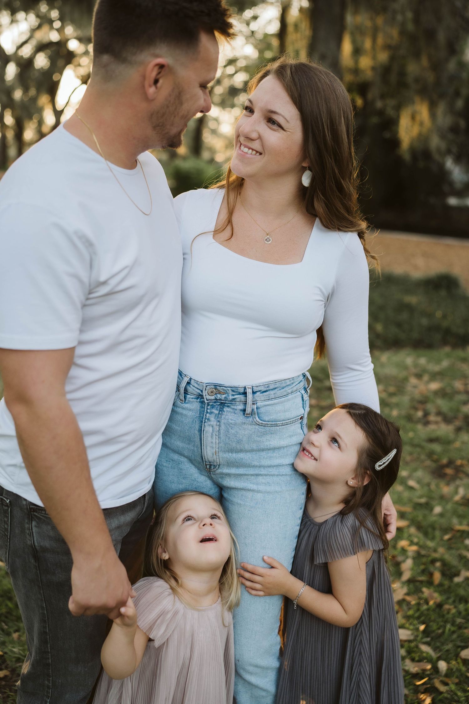 A happy family shares a joyful moment together outdoors during a photo session at sunset.