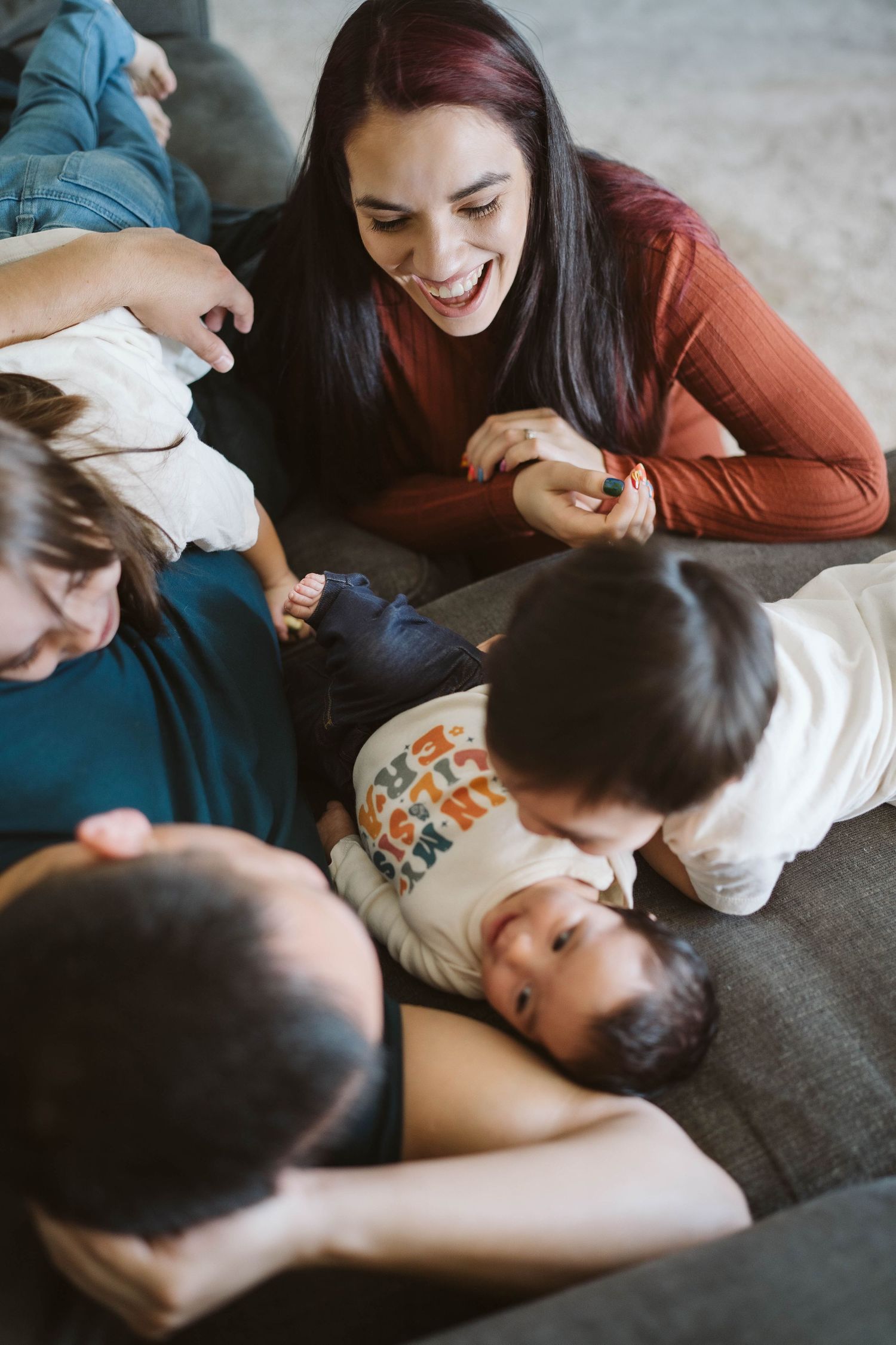 A joyful shared moment among family members relaxing and laughing together on a cozy couch.