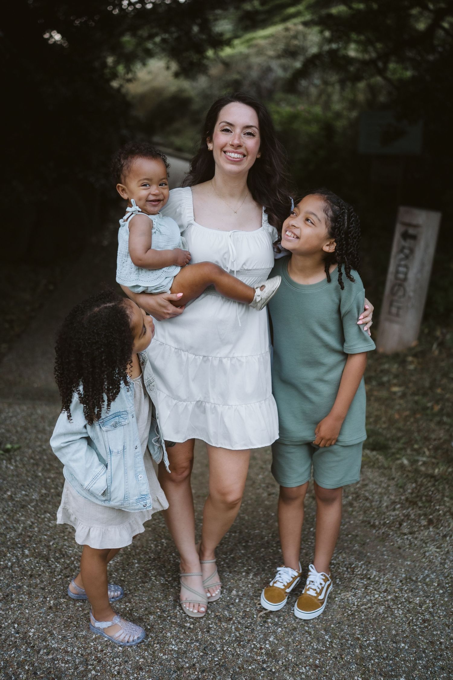 A series of casual outdoor family photos showing children and parent playing together on a gravel path.