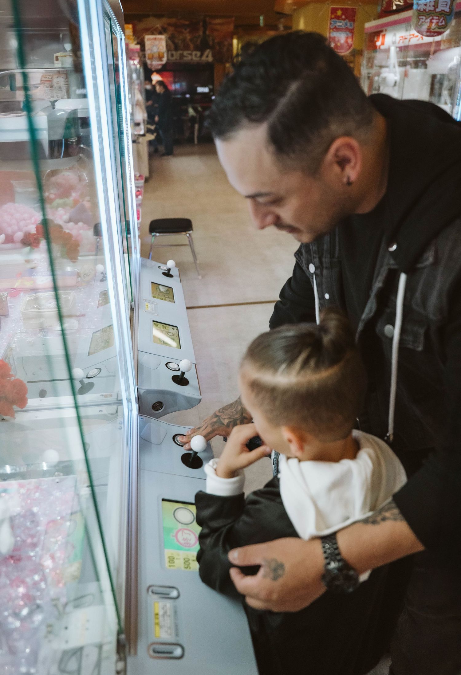 People looking at something together in a display case at what appears to be a shop or museum.