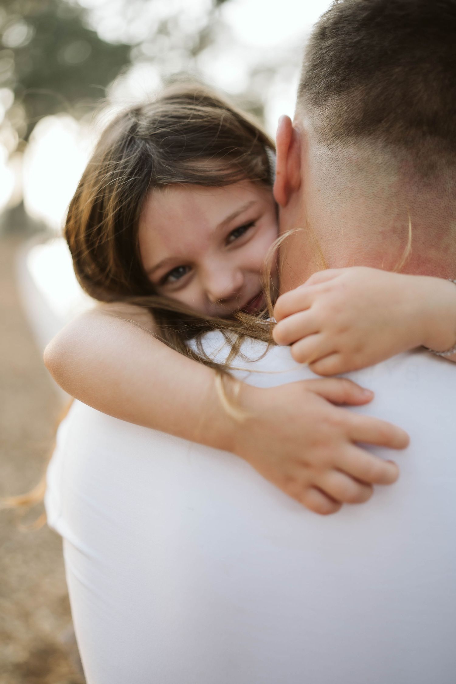 A warm embrace captured in golden sunlight showing a tender moment of affection and joy.