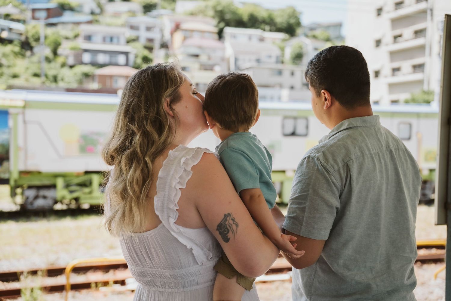 Couple embracing in a romantic outdoor setting with apartment buildings in the background.
