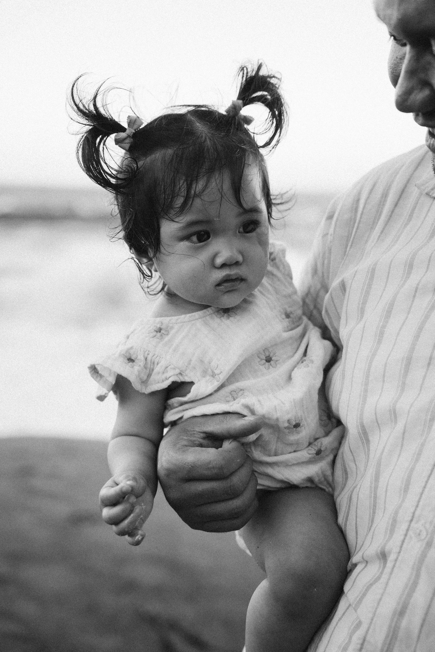 Black and white photo sequence shows a baby in a diaper being held against someone's shoulder in four progressive frames.