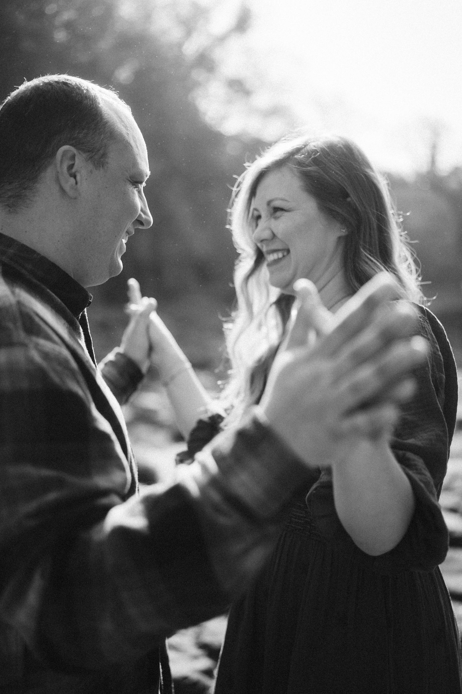 A series of black and white photos showing a couple sharing joyful moments and laughter together.
