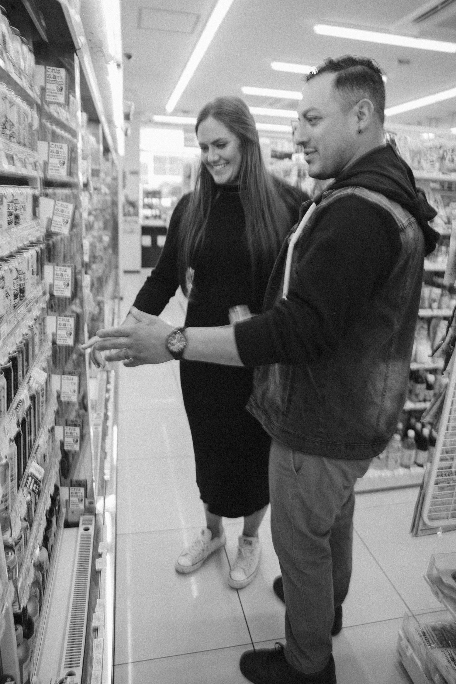 Two people shopping together and browsing items on shelves in a retail store.