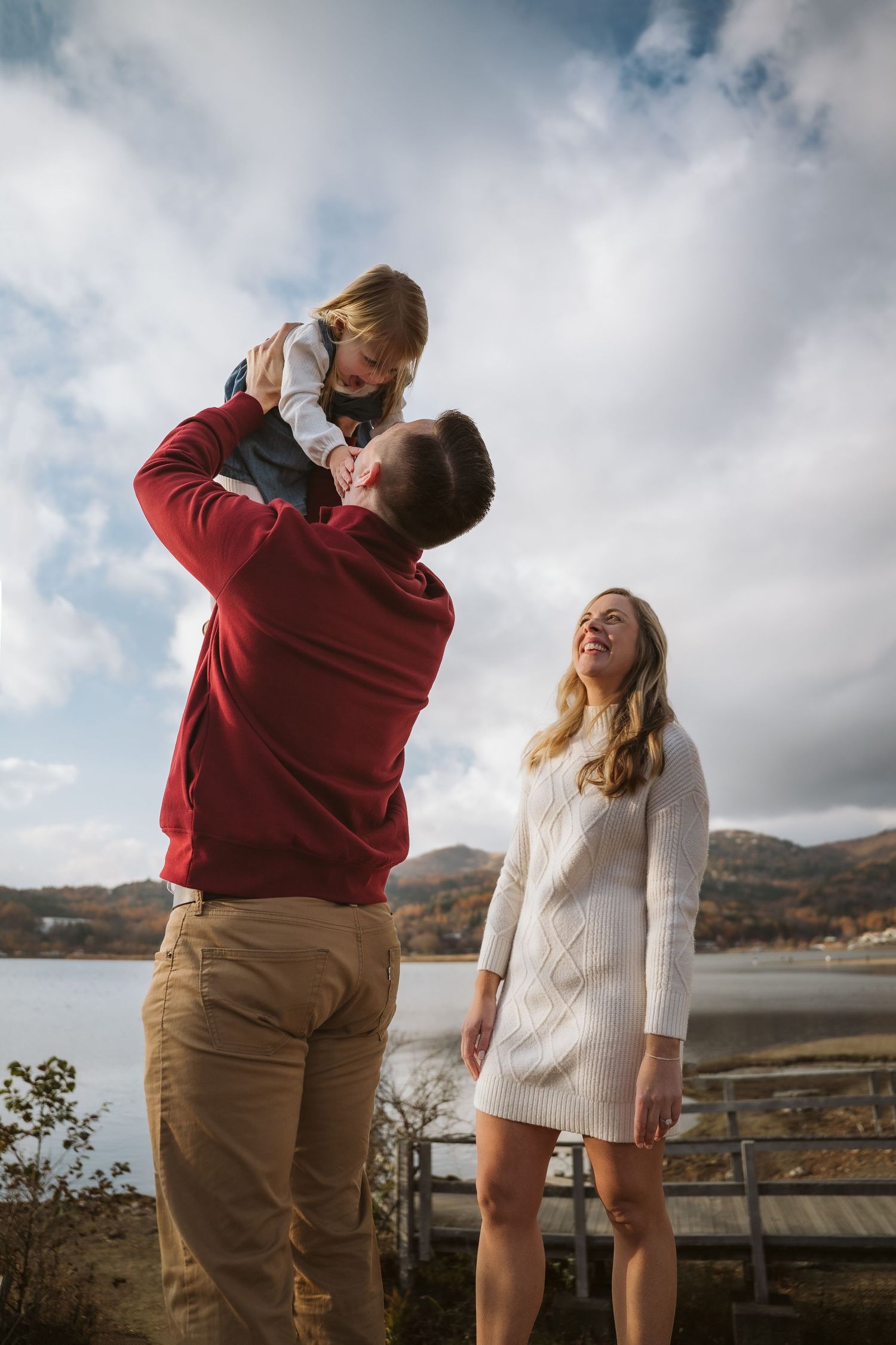 A couple shares tender moments in a series of photos against a cloudy mountain landscape backdrop.