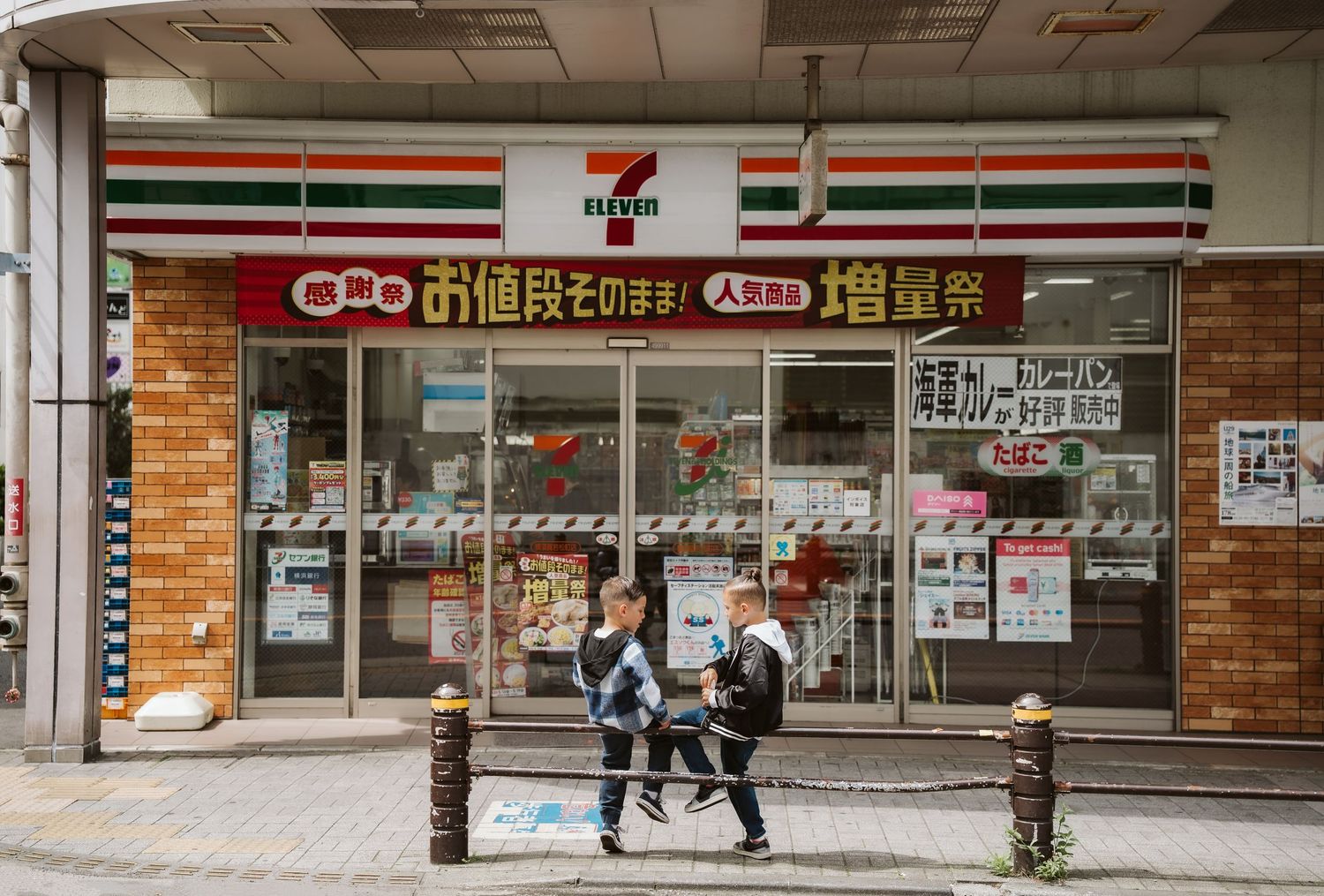 A 7-Eleven convenience store storefront with Chinese characters and striped awning visible in the exterior signage.