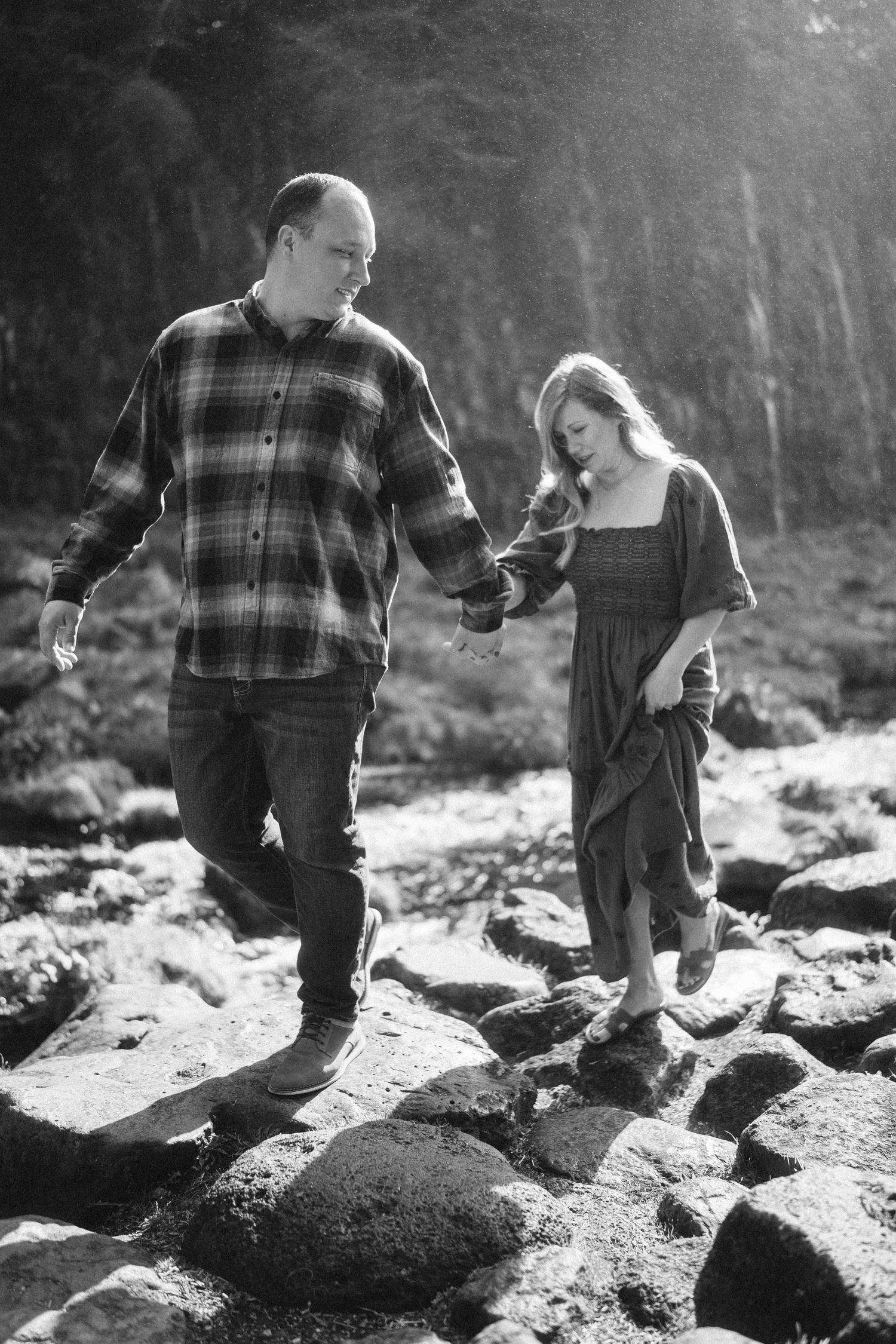A sequence of black and white photos showing two people walking across rocky terrain.