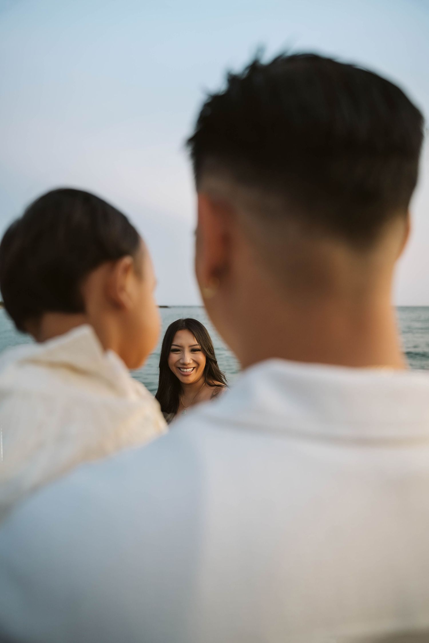 A close-up beachside portrait showing silhouettes against an ocean backdrop.