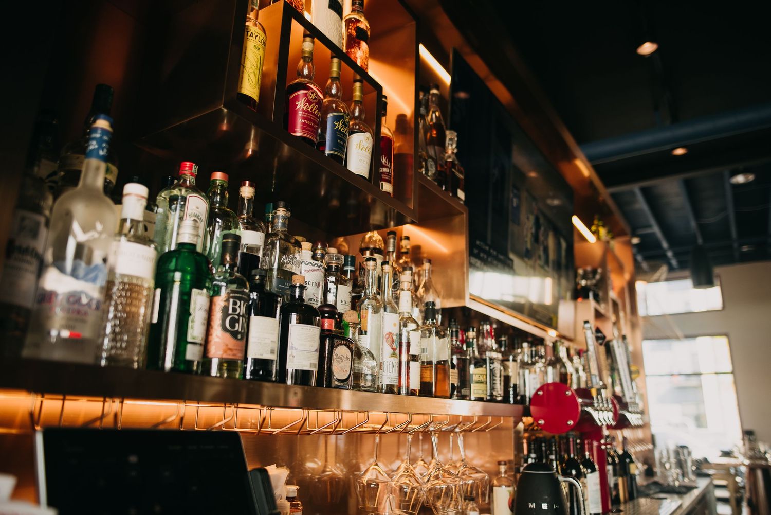 Well-stocked bar shelf displaying an extensive collection of premium spirits and liquor bottles.