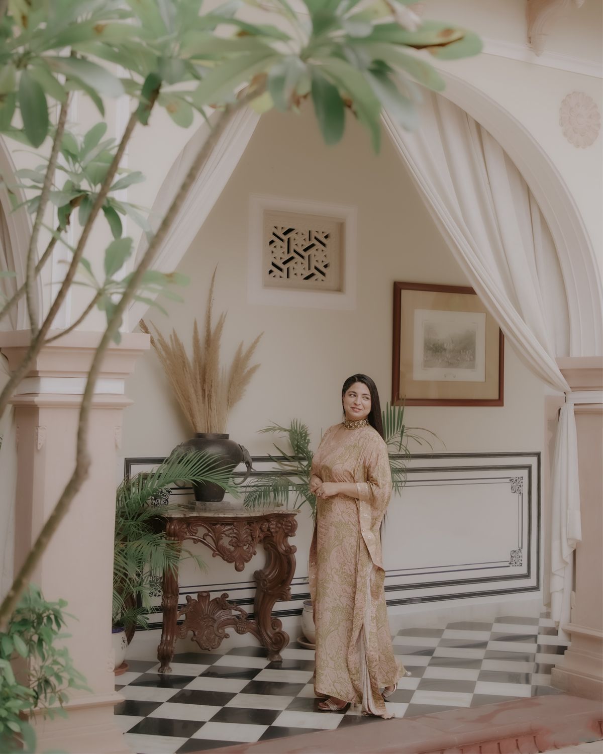 Elegant traditional interior with checkered floors, arched doorways and potted plants creating a luxurious atmosphere.