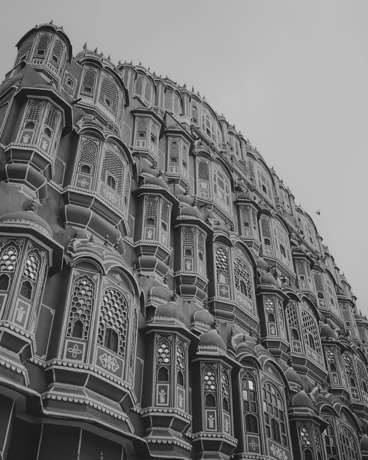 Detailed architectural view of Hawa Mahal's iconic honeycomb facade in black and white.