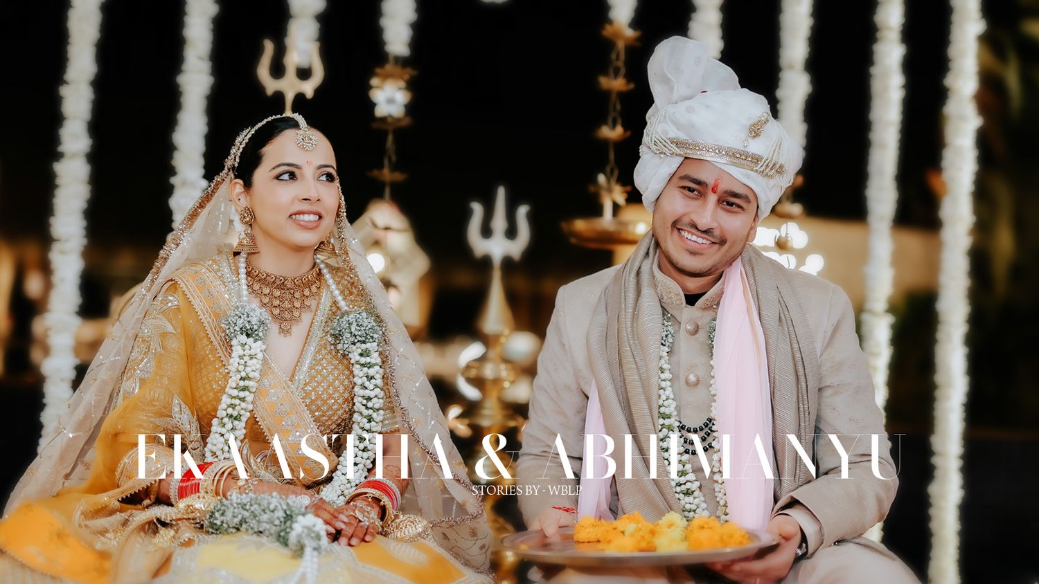 Traditional Indian wedding ceremony with couple seated at decorated mandap.
