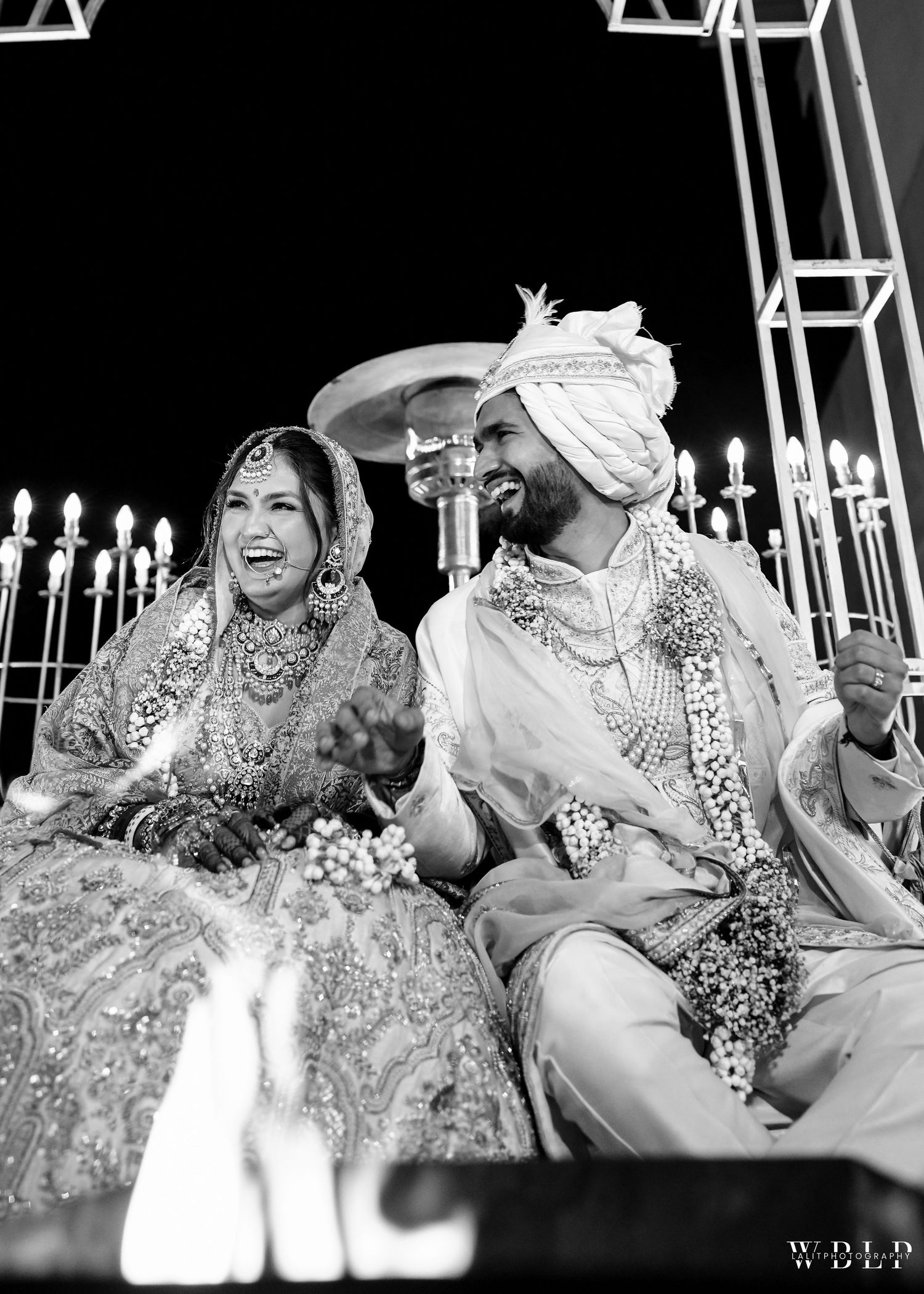 Black and white wedding ceremony photo with traditional Indian outfits and decor.