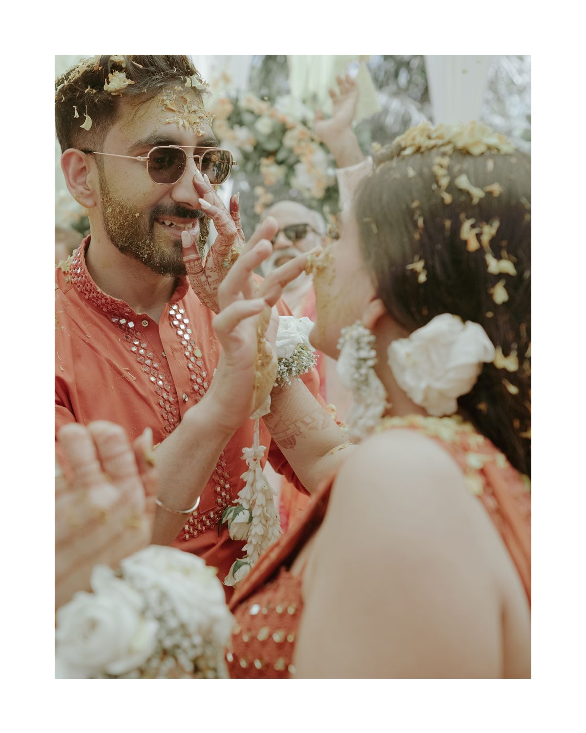 A joyous celebration at a traditional Indian wedding with confetti and guests wearing festive attire.