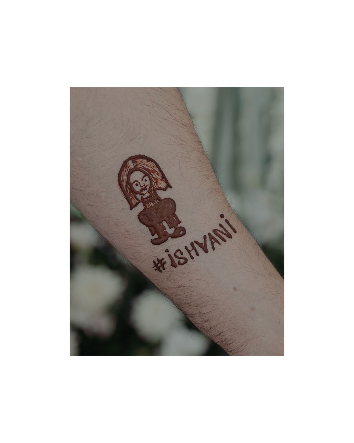 Close-up of a cute cartoon character temporary tattoo with text on someone's arm.