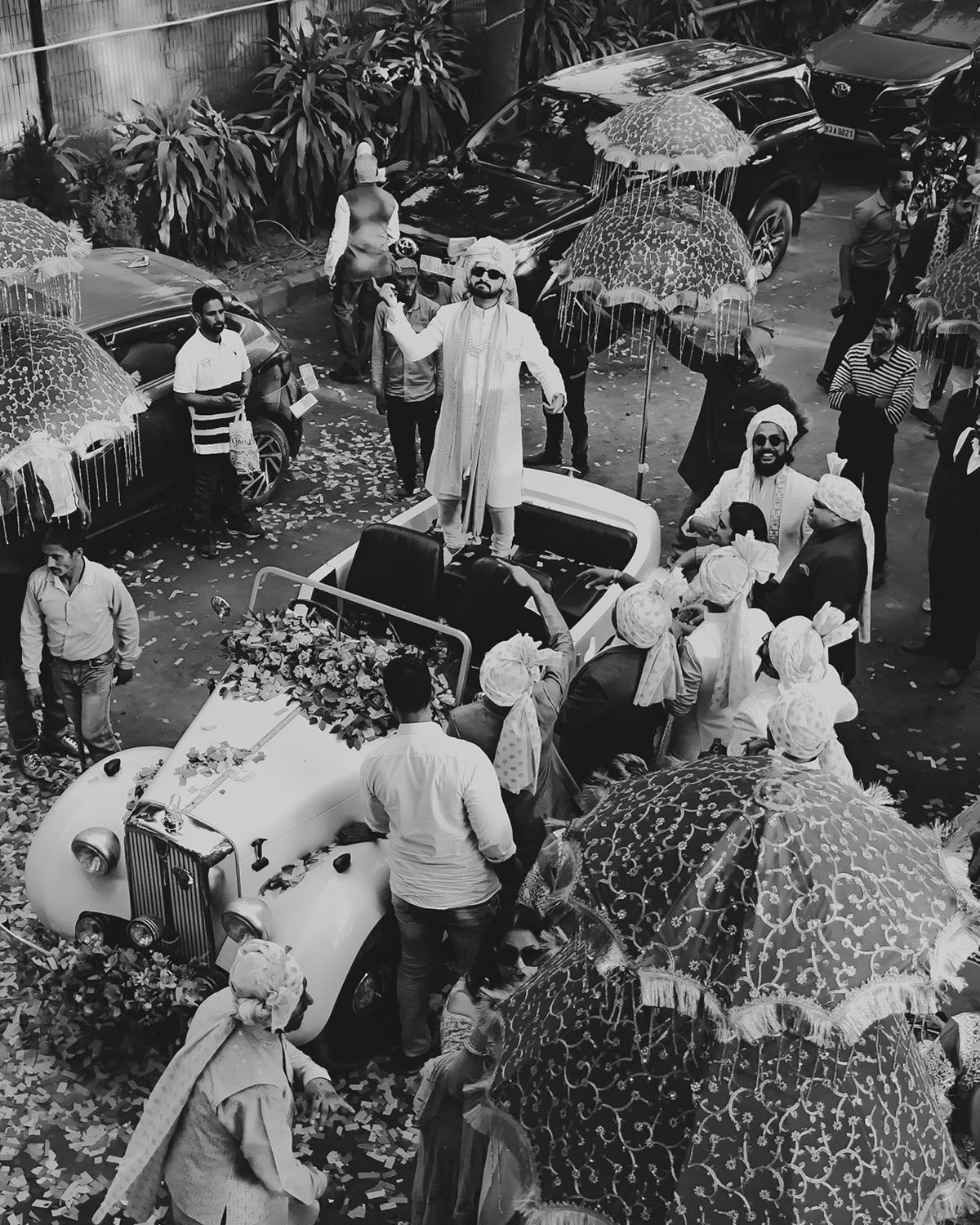 A vintage black and white aerial view of a bustling market scene with umbrellas and vendors selling goods.