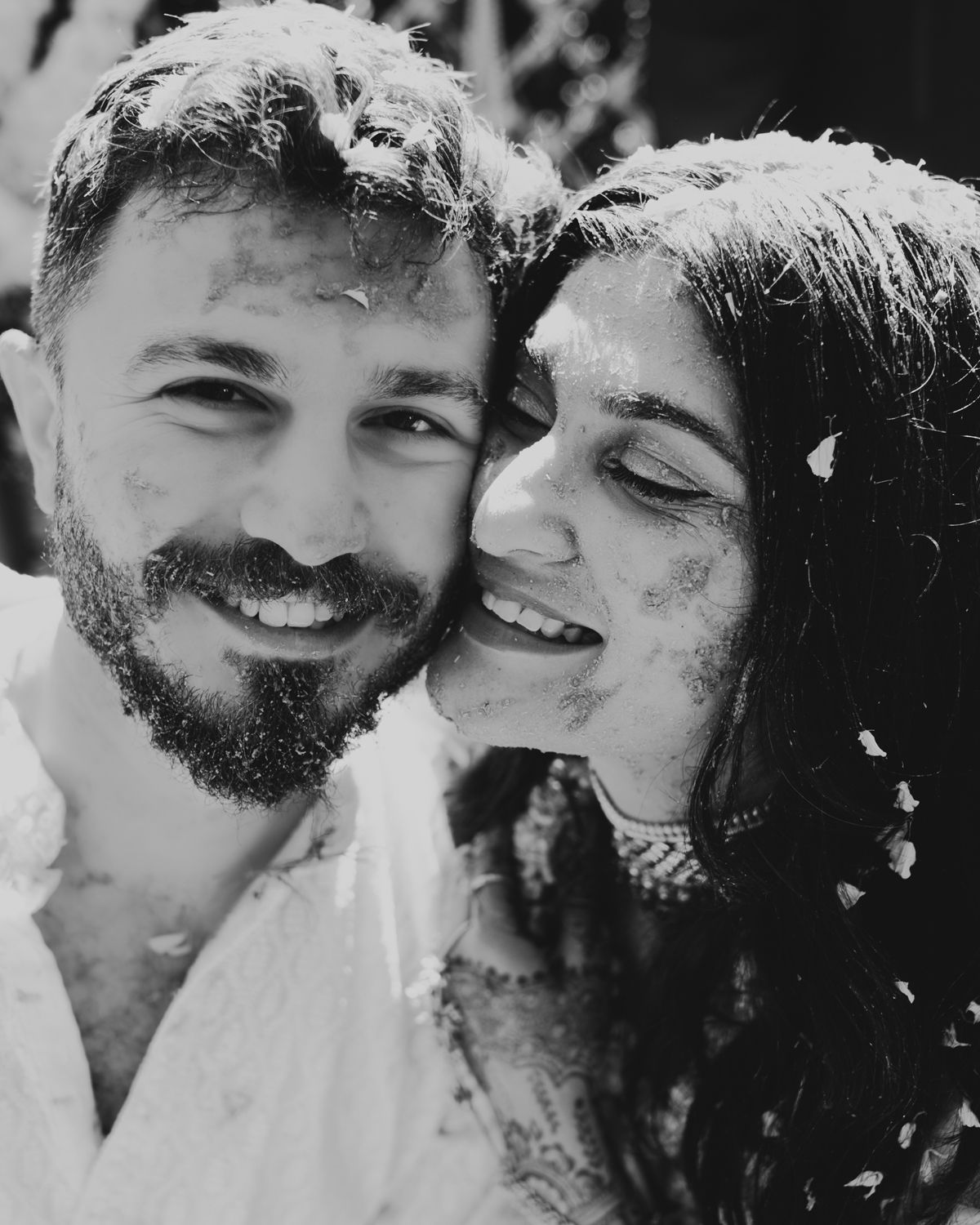 A black and white portrait of a happy couple sharing an intimate moment.
