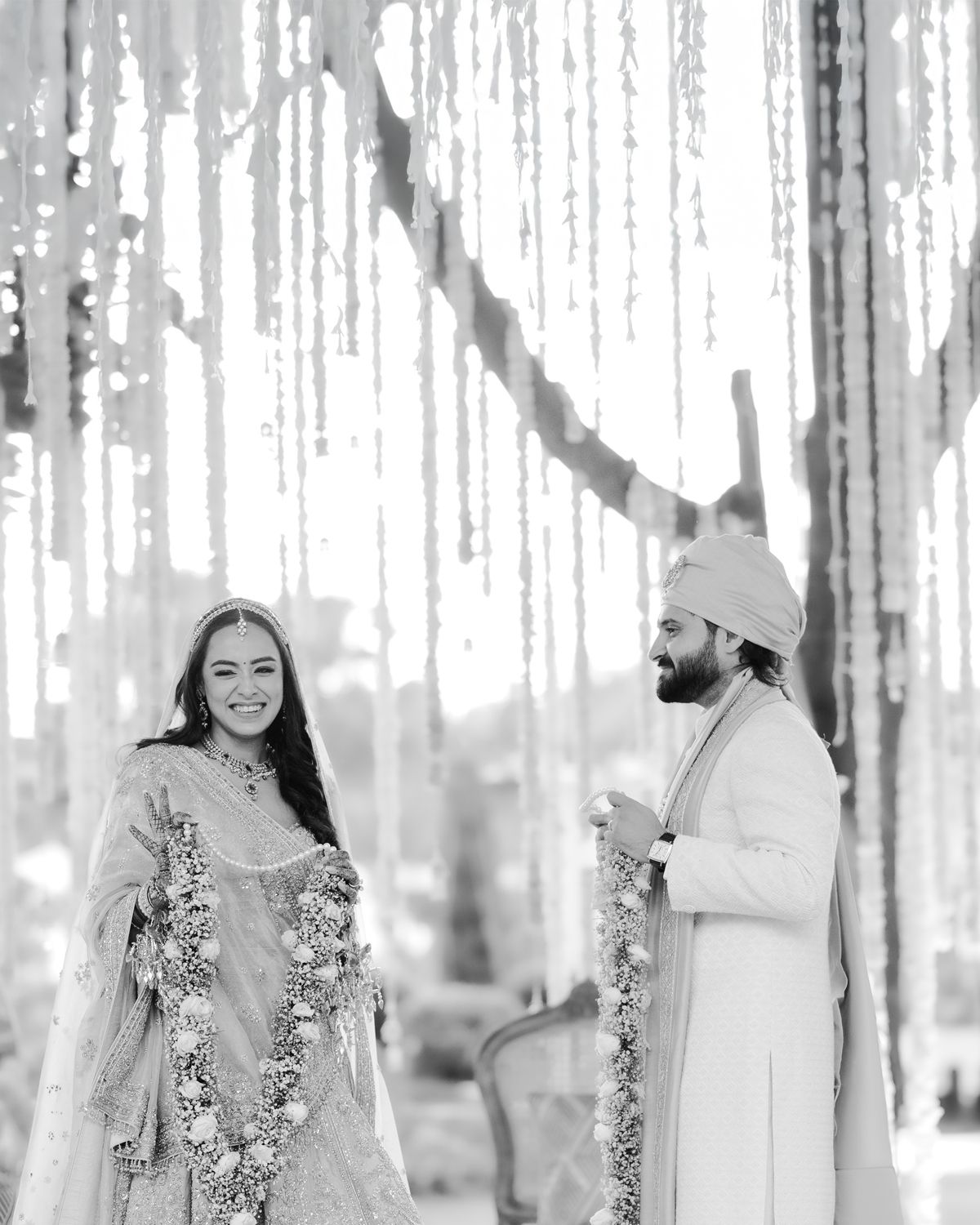 A wedding celebration with hanging string lights and floral decorations creating a magical atmosphere.