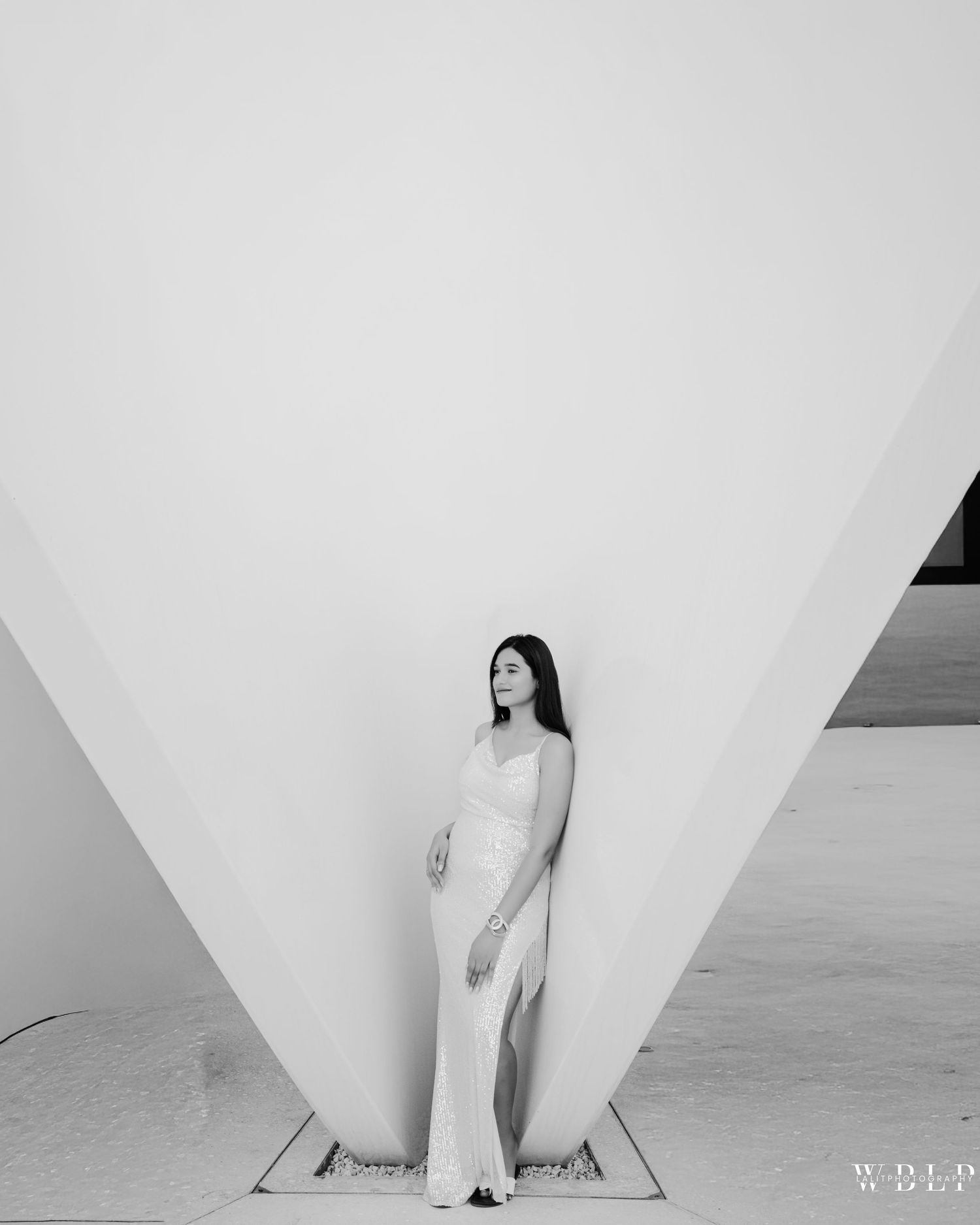 A minimalist black and white photo series showing a person posing against geometric white architectural walls.