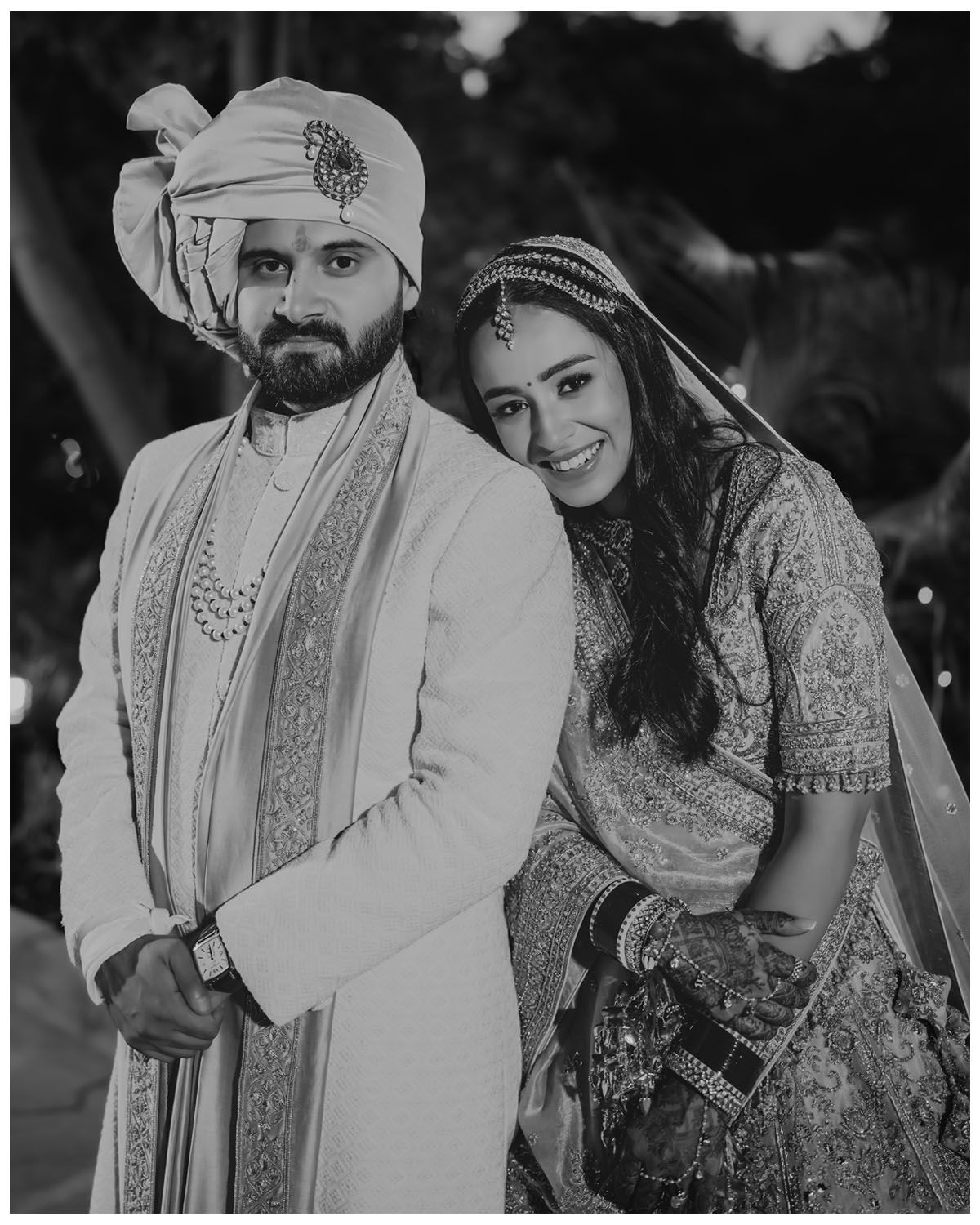 Black and white wedding portrait showing traditional Indian formal attire.