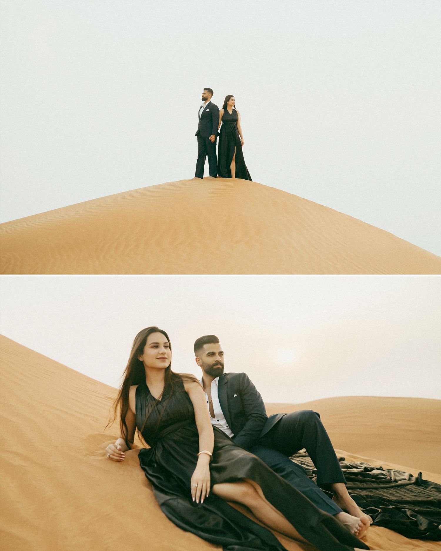Couple in elegant black attire posing on golden sand dunes in a desert landscape for a romantic photoshoot.