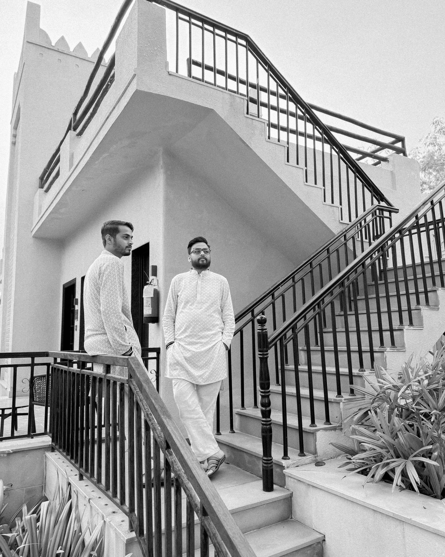 Black and white architectural photo showing a modern staircase with iron railings.