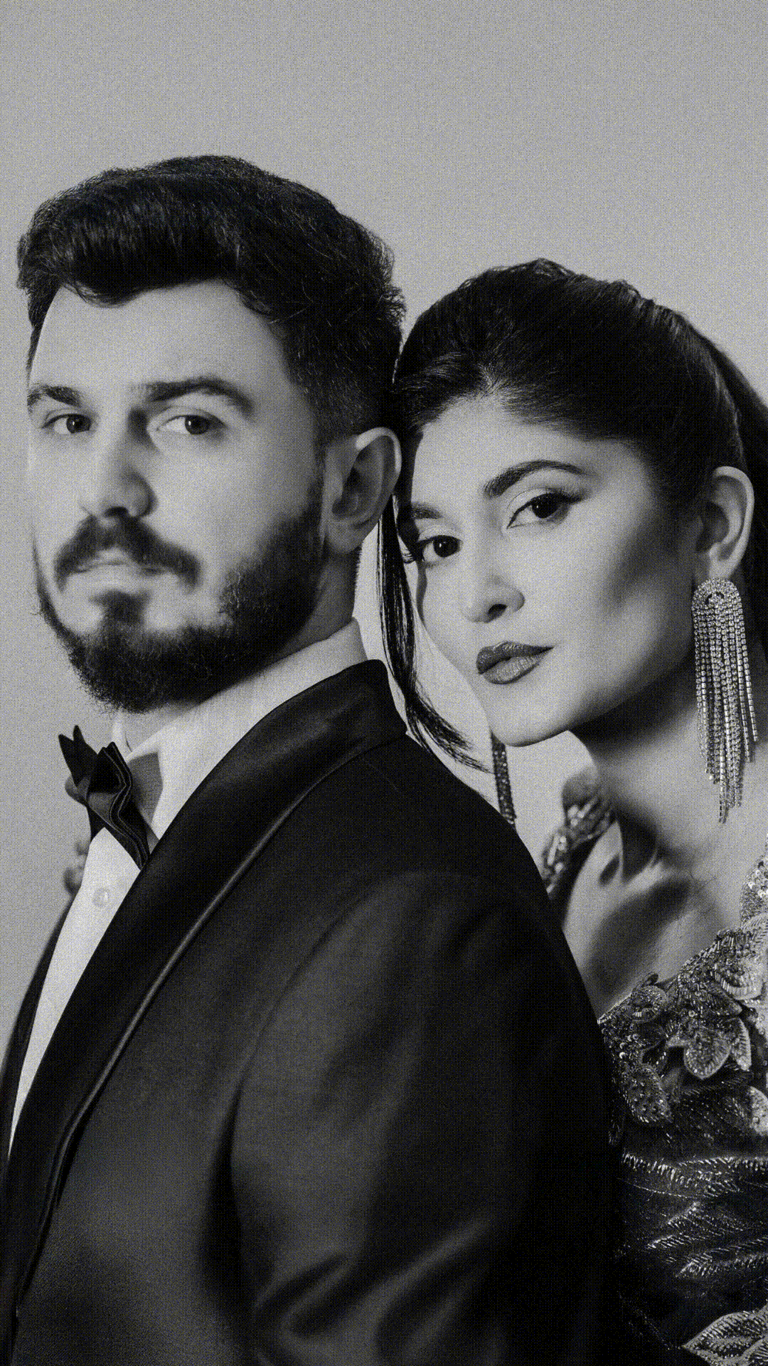 High contrast black and white portrait of two people in formal evening wear.
