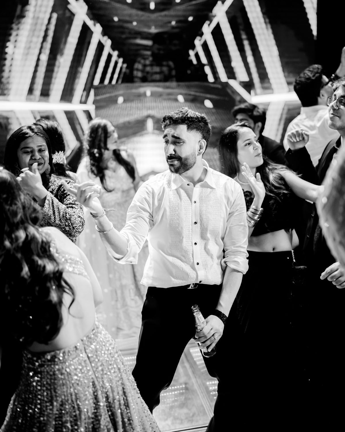 People dancing and celebrating on a dance floor with illuminated decor.