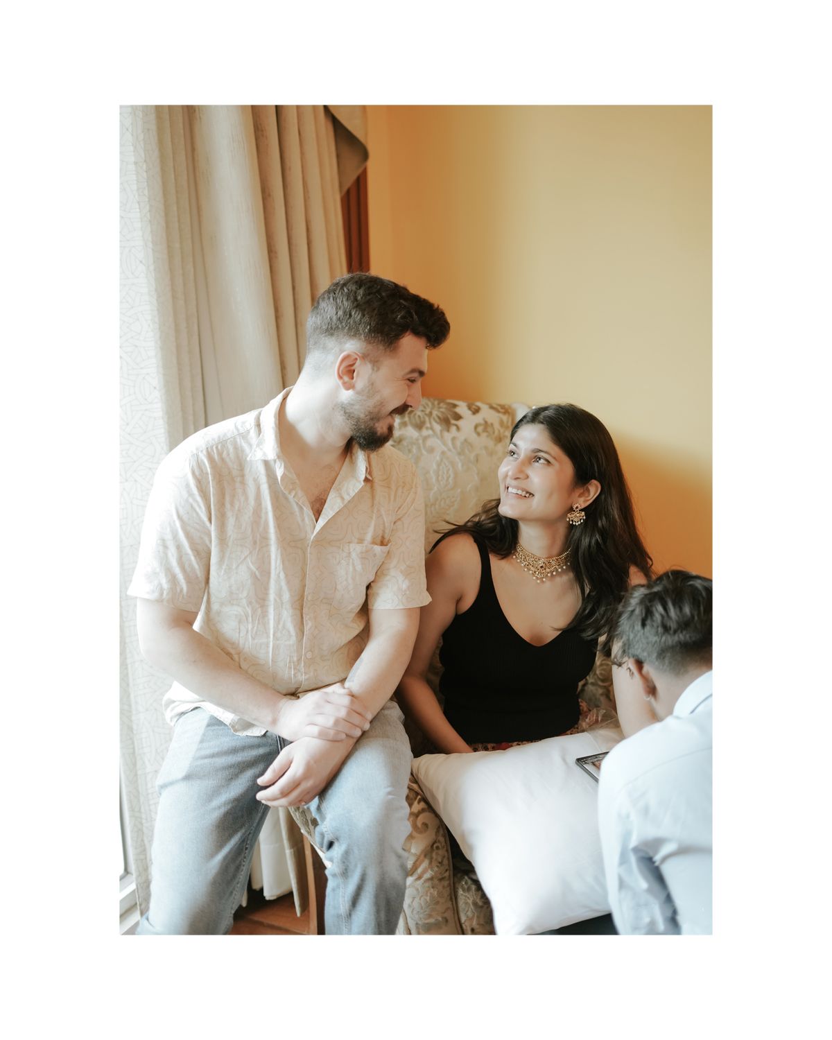 Candid moment of couple sharing laughter during pre-wedding photoshoot in casual attire.